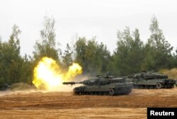 Танк Leopard 2 испанской армии ведет огонь во время заключительного этапа военных учений Silver Arrow-2022 на военном полигоне в Латвии. 29 сентября 2022 года