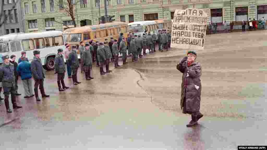 Литва СССР құрамынан шығатынын жарияланғаннан кейін Вильнюс қаласындағы телеорталықты совет әскерінің басып алуына наразылық білдіріп шеруге шыққан әйел &quot;Тойынған партноменклатура, жолды босат! Халық сені жек көреді!&quot; деген жазу ұстап тұр. Мәскеу, 13 қаңтар 1991 жыл.