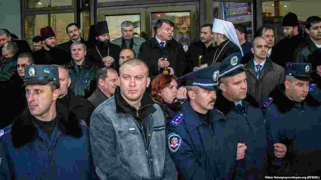 Председатель Совмина АРК Анатолий Бурдюгов (в центре), управляющий Крымской епархией УПЦ МП Владыка Лазарь (справа), архиепископ Симферопольский и Крымский УПЦ КП Климент (слева), а также представители различных органов крымской власти. Все они находились на ступеньках торгового центра под экраном. В руках держали свечи в память о жертвах трагедии. От агрессивно настроенных активистов их охраняли представители милиции