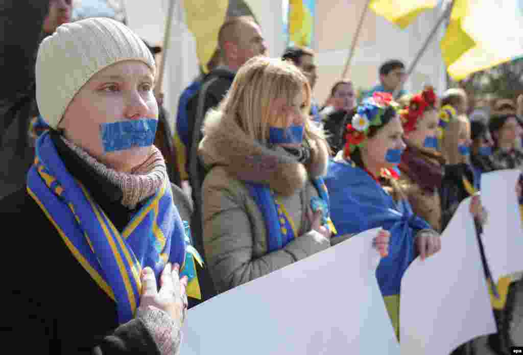 Участницы акции, представительницы движения &laquo;Женщины Крыма за МИР&raquo;, провели в Симферополе молчаливую акцию в поддержку свободы слова. Девушки заклеили себе рты синей лентой, а в руках держали чистые плакаты без единой буквы. 13 марта&nbsp;