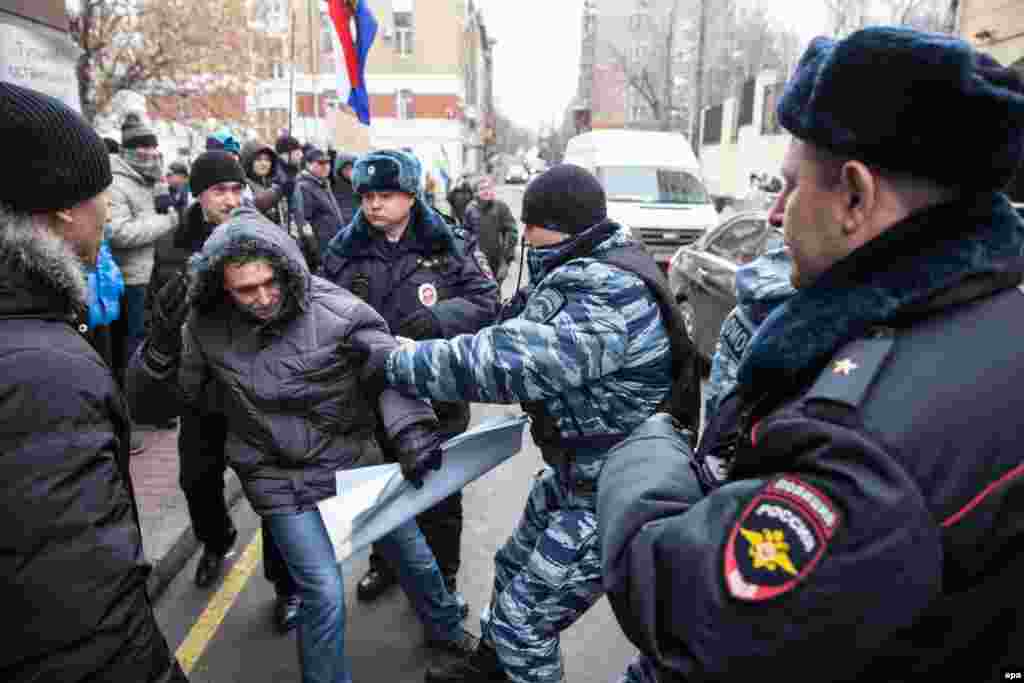 Полицейские задерживают одного из участников акции протеста у посольства Турции 25 ноября