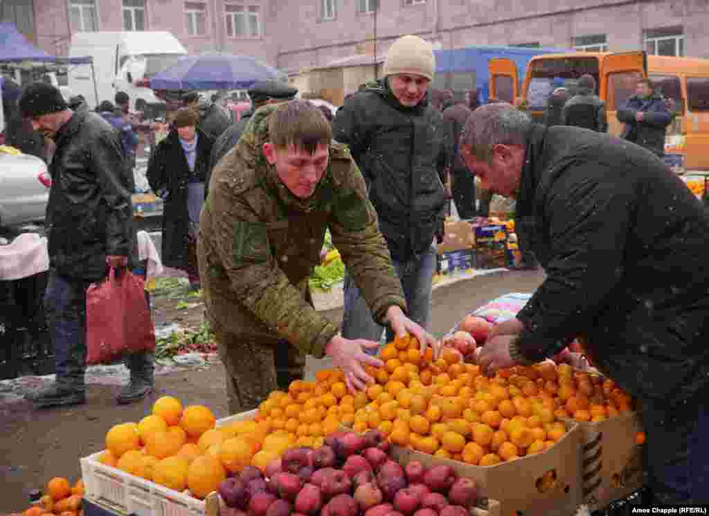 Российский военнослужащий покупает мандарины на центральном рынке Гюмри. Во время расследования убийства семьи Аветисян было выявлено масштабное хищение продуктов, на сумму в 7 миллионов 800 тысяч долларов, предназначавшихся Минобороны России для питания своих военнослужащих в Армении. Все продукты были украдены и потом вновь перепроданы на местных рынках.